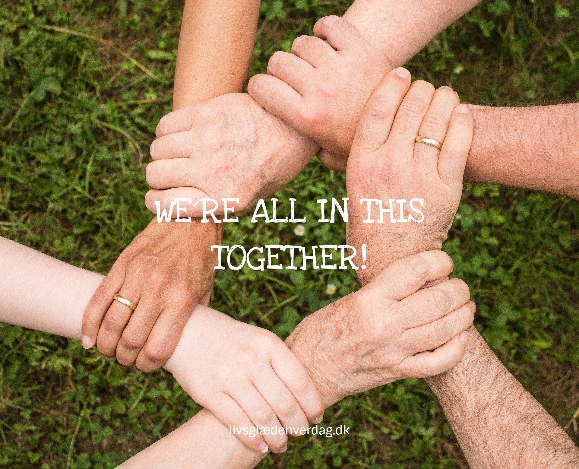 Seks hænder som griber om hinanden og teksten: We´re all in this together!